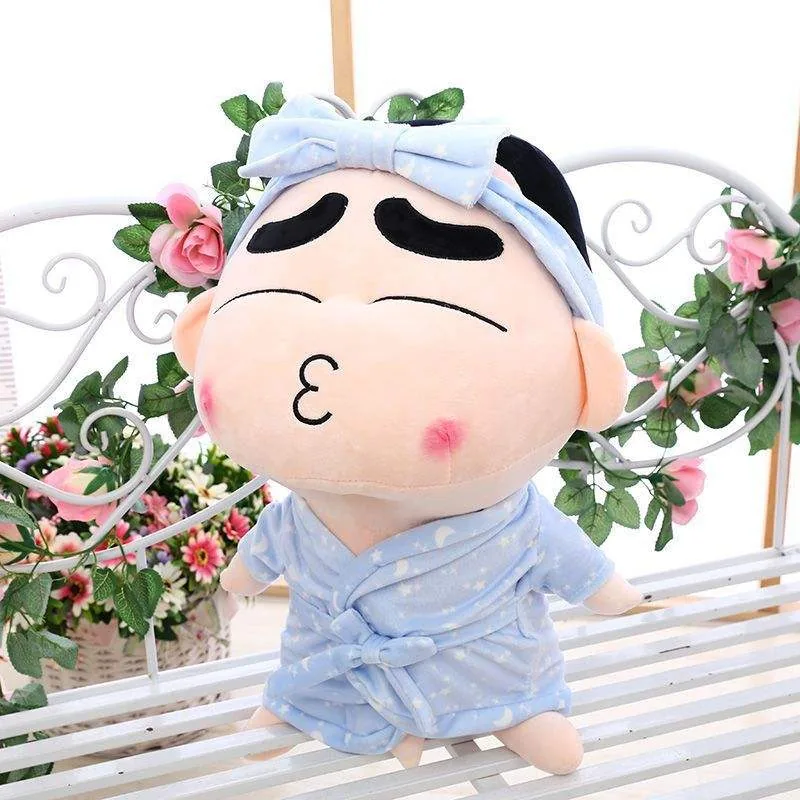 Close-up of a Crayon Shin-chan pajama plush doll with blush cheeks, closed eyes, and a pale blue bow headband